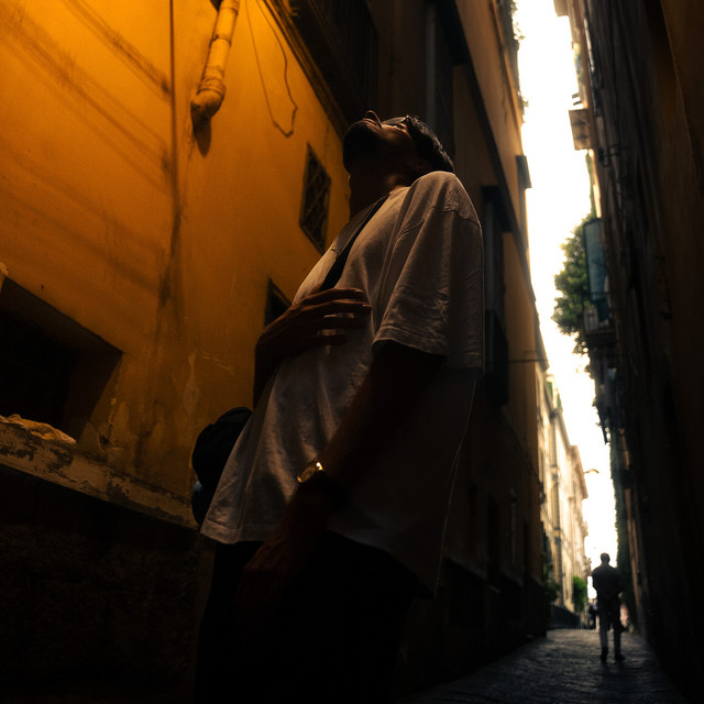 Pochette de Détresse : Langa lève les yeux vers le ciel dans une ruelle étroite aux murs ocre