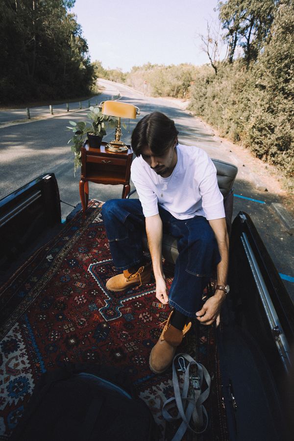 Langa lace ses chaussures sur un tapis persan, à l’arrière du pick-up